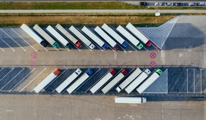 Vista aérea de vários caminhões estacionados lado a lado em duas fileiras.