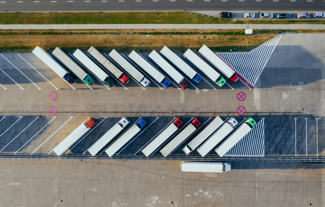 Vista aérea de vários caminhões estacionados lado a lado em duas fileiras.