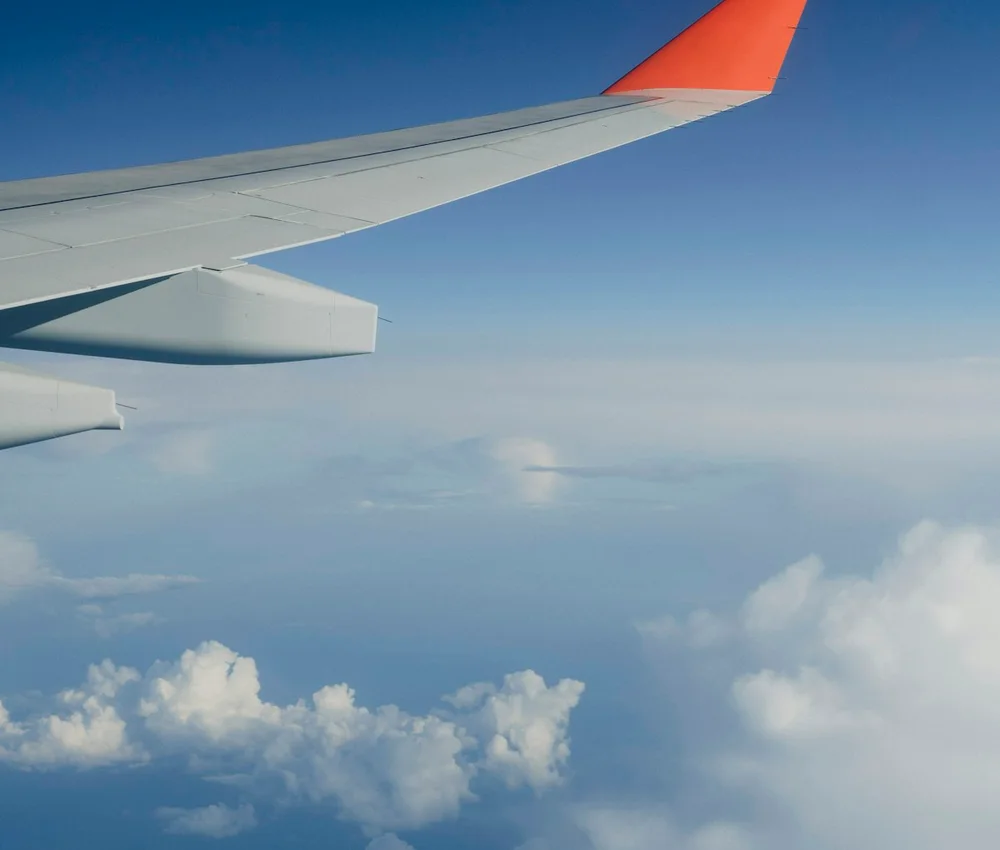 Asa de avião vista da janela durante um voo acima das nuvens.