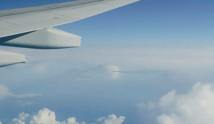Asa de avião vista da janela durante um voo acima das nuvens.